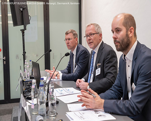 men on a panel discussion at a conference