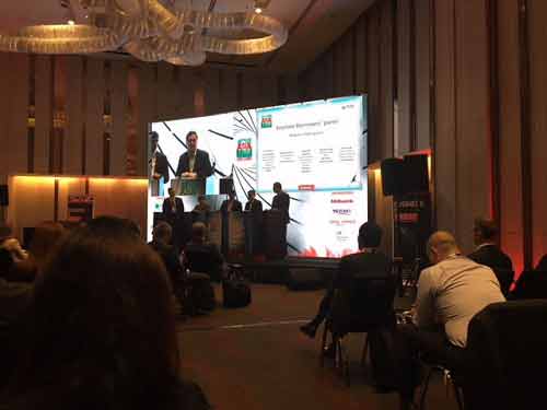 people talking on a panel at a conference